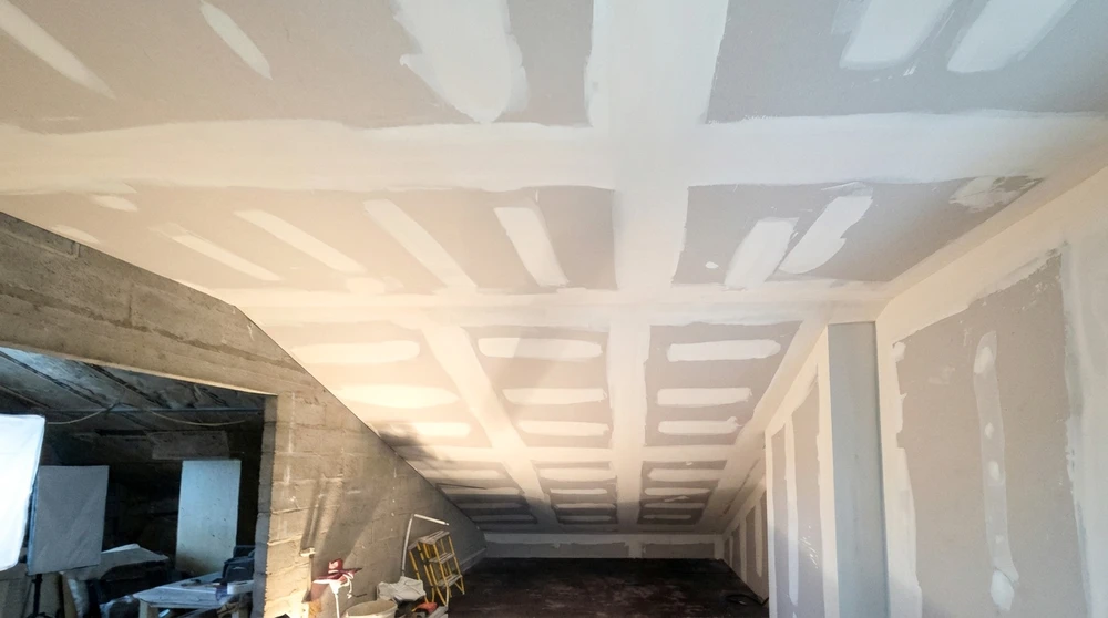 Chantier intérieur en cours, plafond en plaques de plâtre (BA13) avec joints enduits à la bande, fixées sur ossature métallique